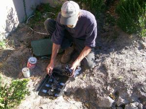 a Kenmore sprinkler repair tech is doing a maintenance check on a valve box