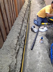 a technician is laying down the lines for a new sprinkler system installation